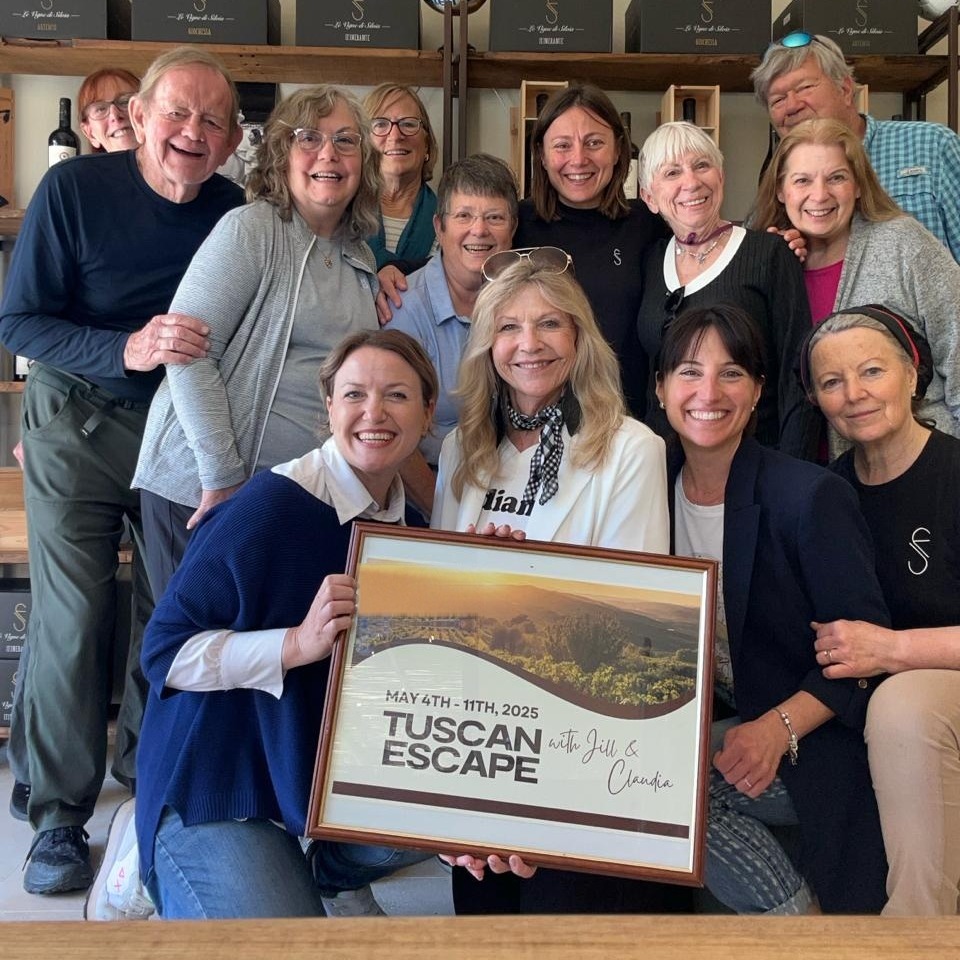 The Tuscan Escape group in 2025 with Claudia and Jill, holding the framed poster
