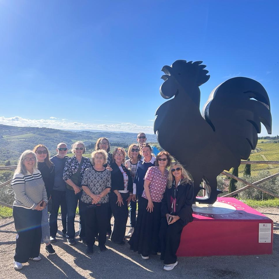 Claudia's wine travel group at the Gallo Nero statue in Chianti Classico